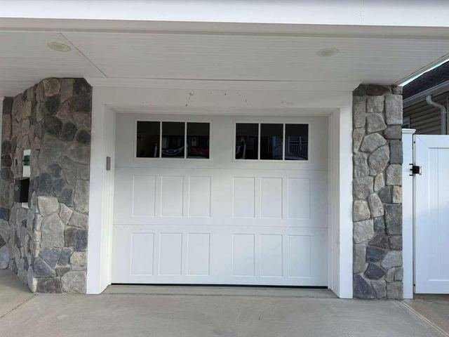 Carriage style garage door with stone pillars