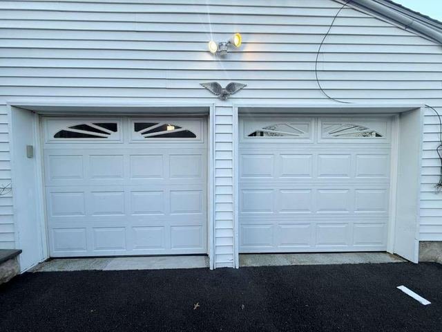 Two white garage doors with sunburst windows