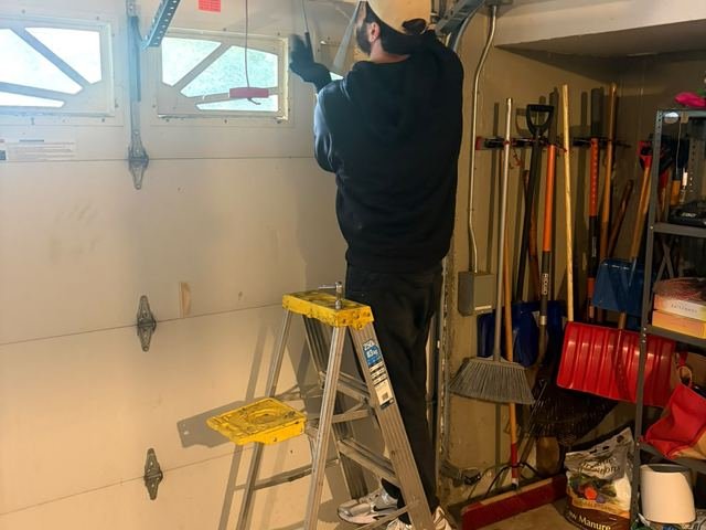 Pro Line technician servicing garage door springs and cables